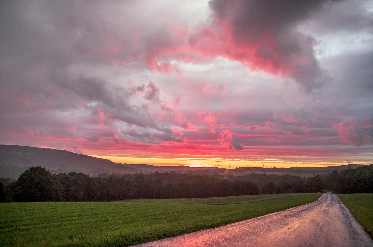 A colorful sunset fills the sky on Douglas Hall Road in Franklin after a downpour in 2022.